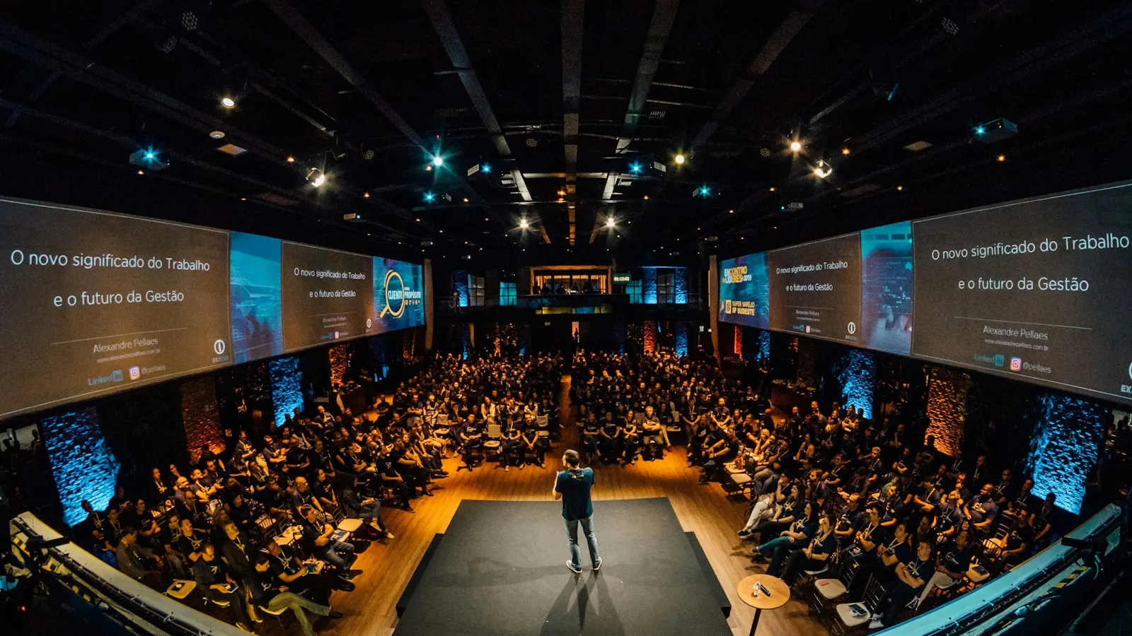 A speaker on stage addressing a large conference audience