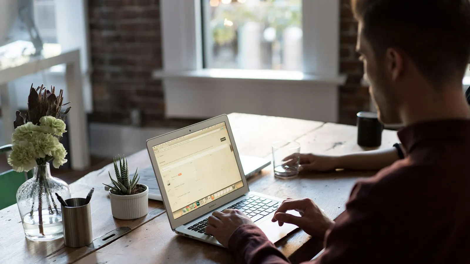 An accountant working on a laptop at a wooden desk