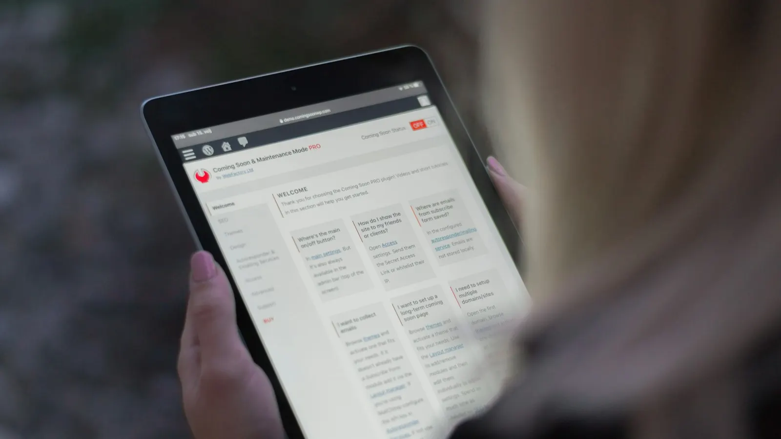 A hand holding a tablet showing a scheduling app