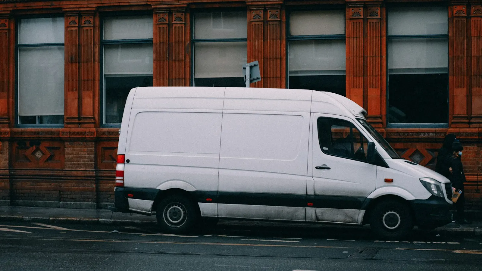 A white service van parked on a city street