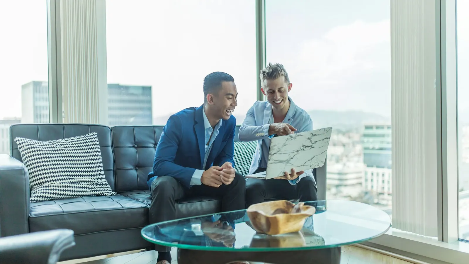 Two advisors reviewing a laptop on an office sofa