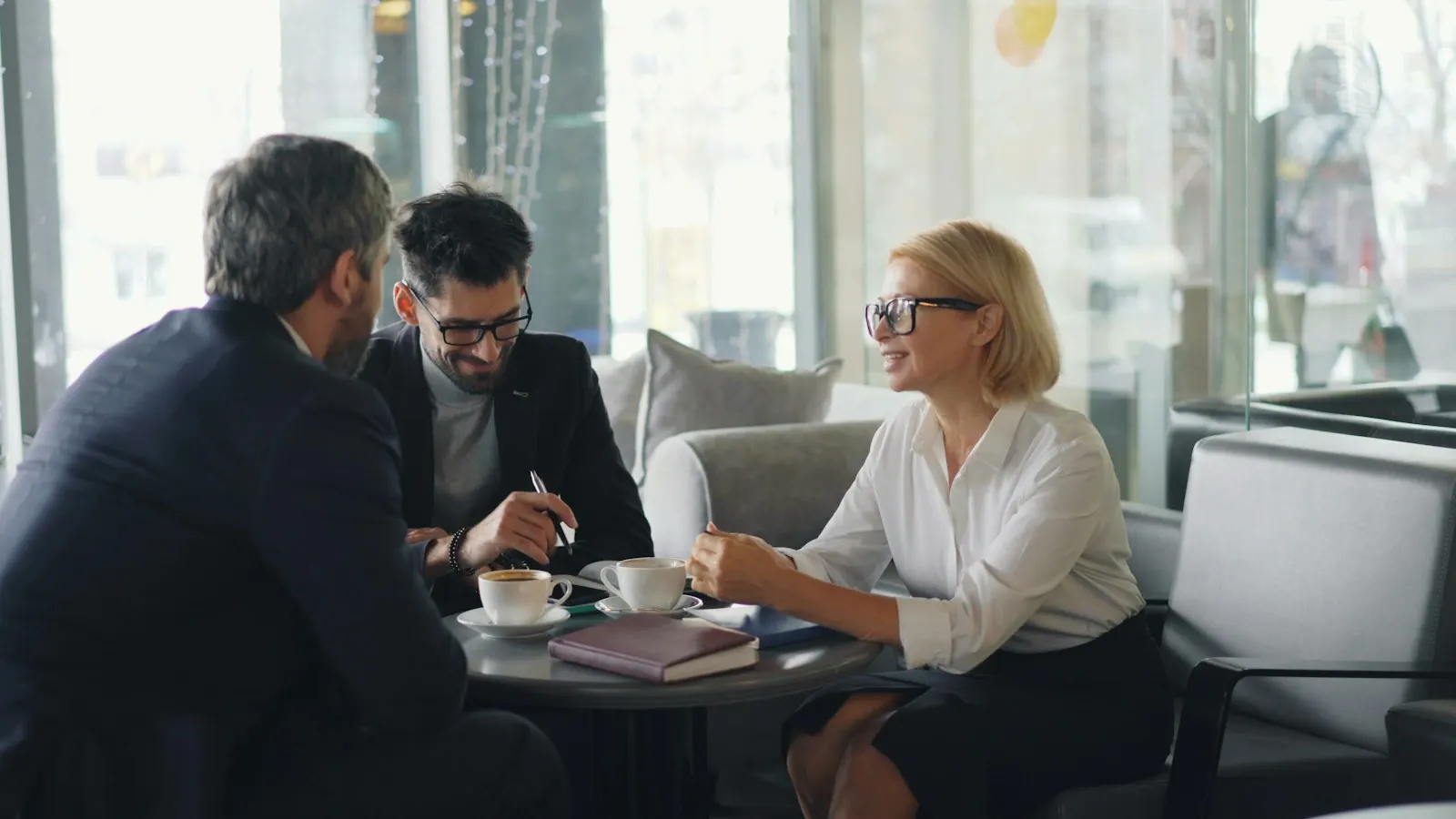 An advisor meeting two clients over coffee