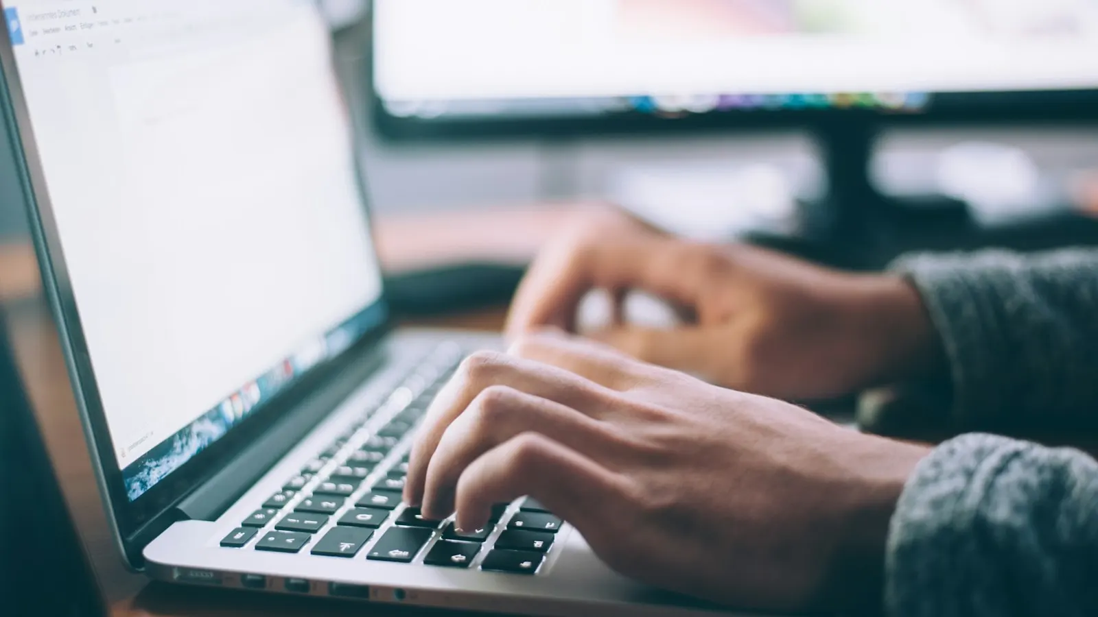 Hands typing a document on a laptop