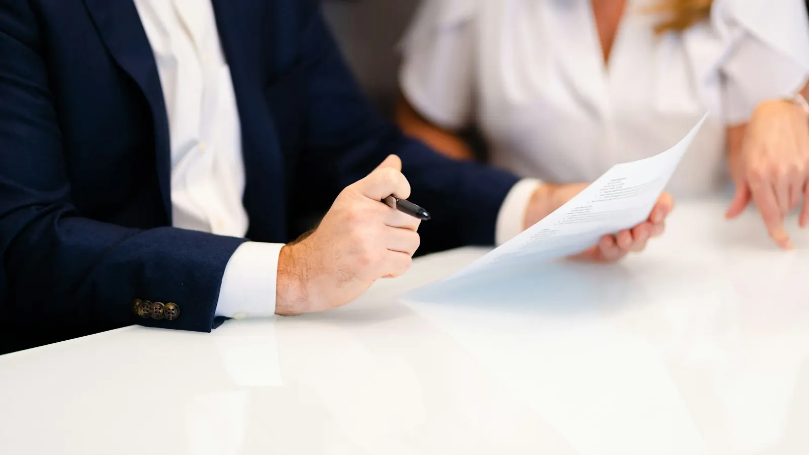 Two people reviewing a document together at a white table