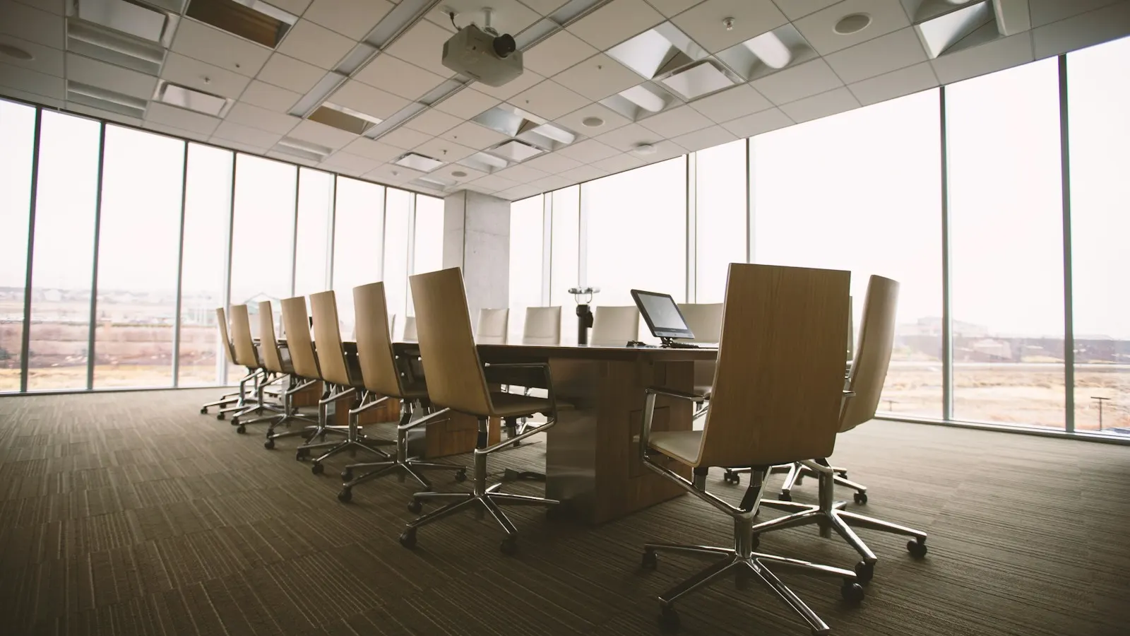 An empty boardroom with a long conference table