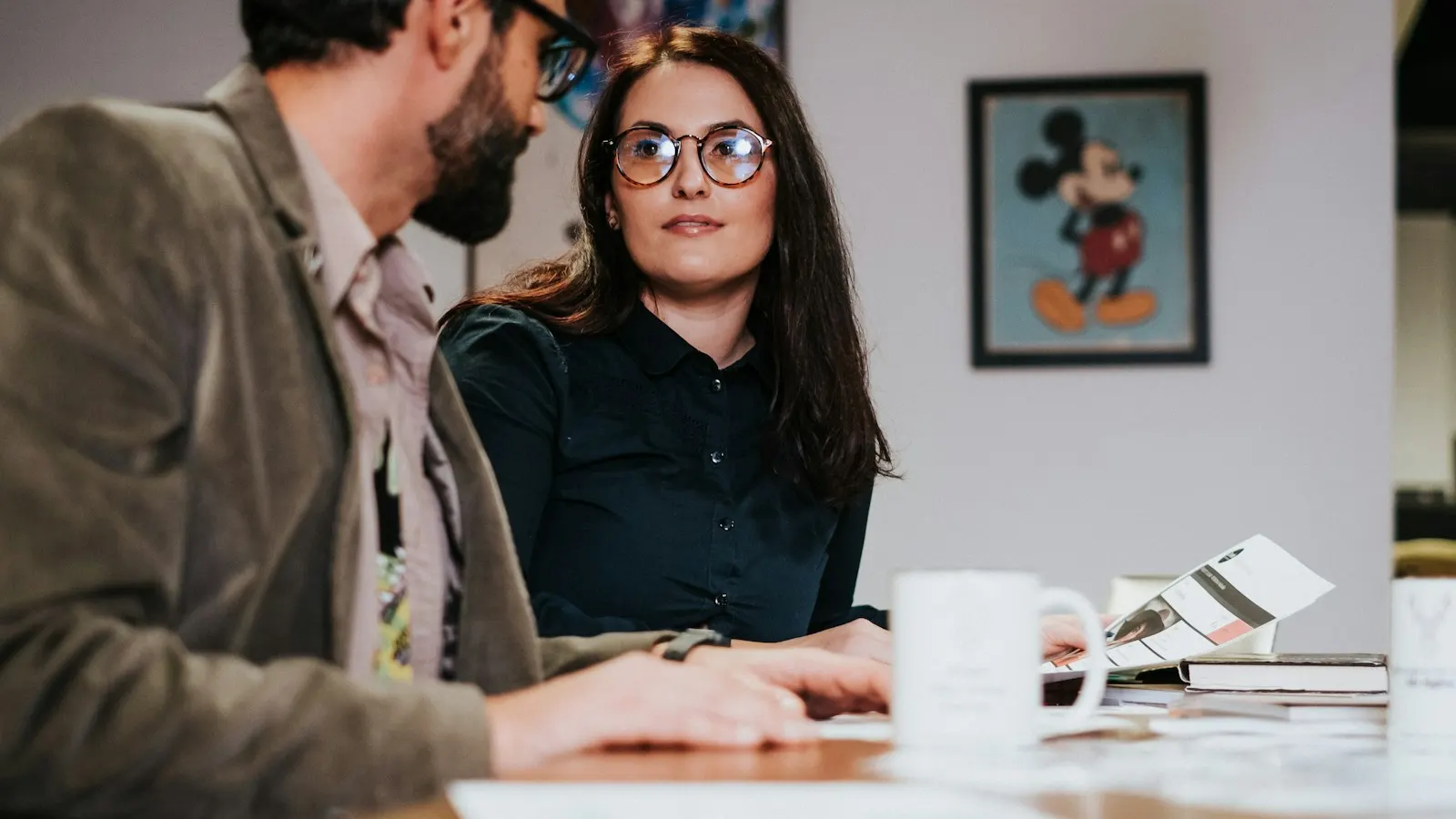 An agent and a client discussing paperwork at a table