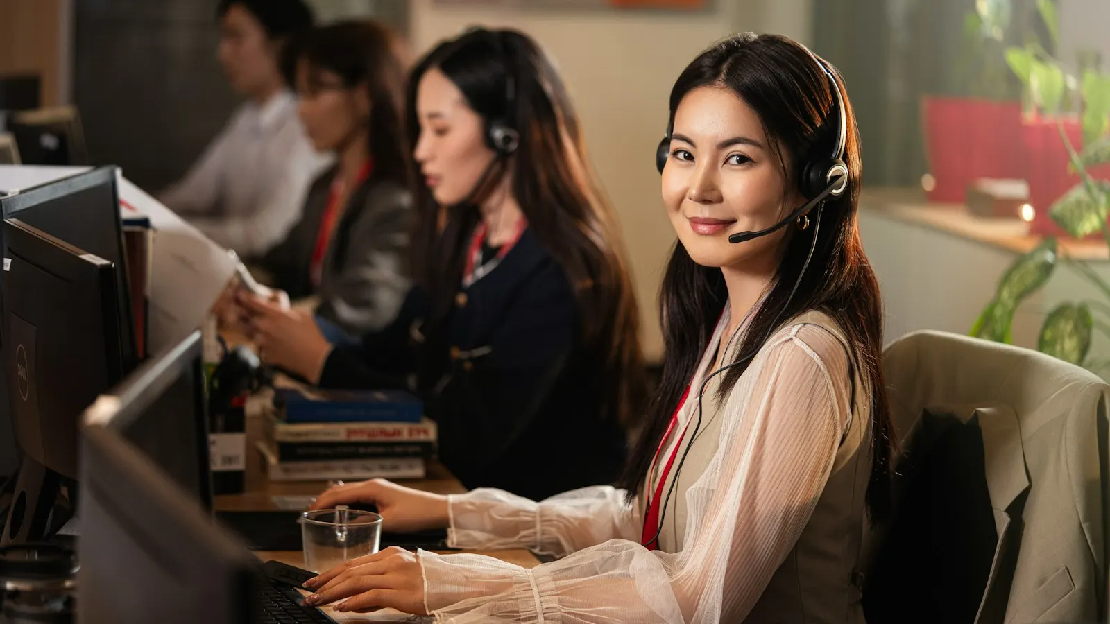 Sales agents wearing headsets at their desks