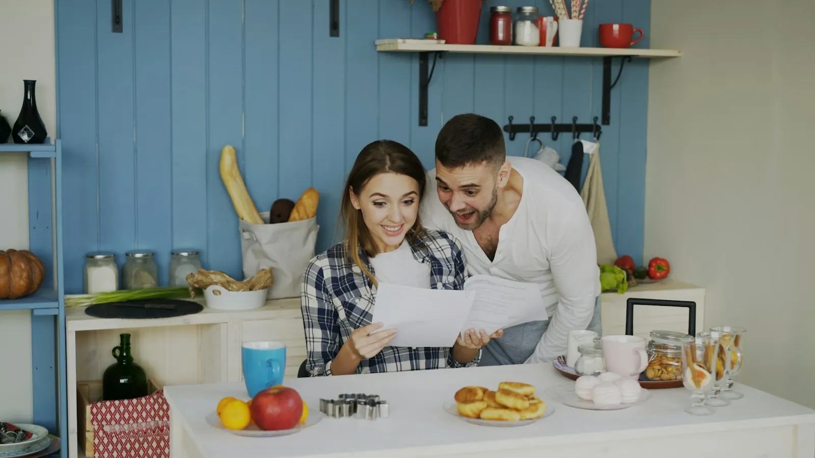 A couple reading documents together in their kitchen