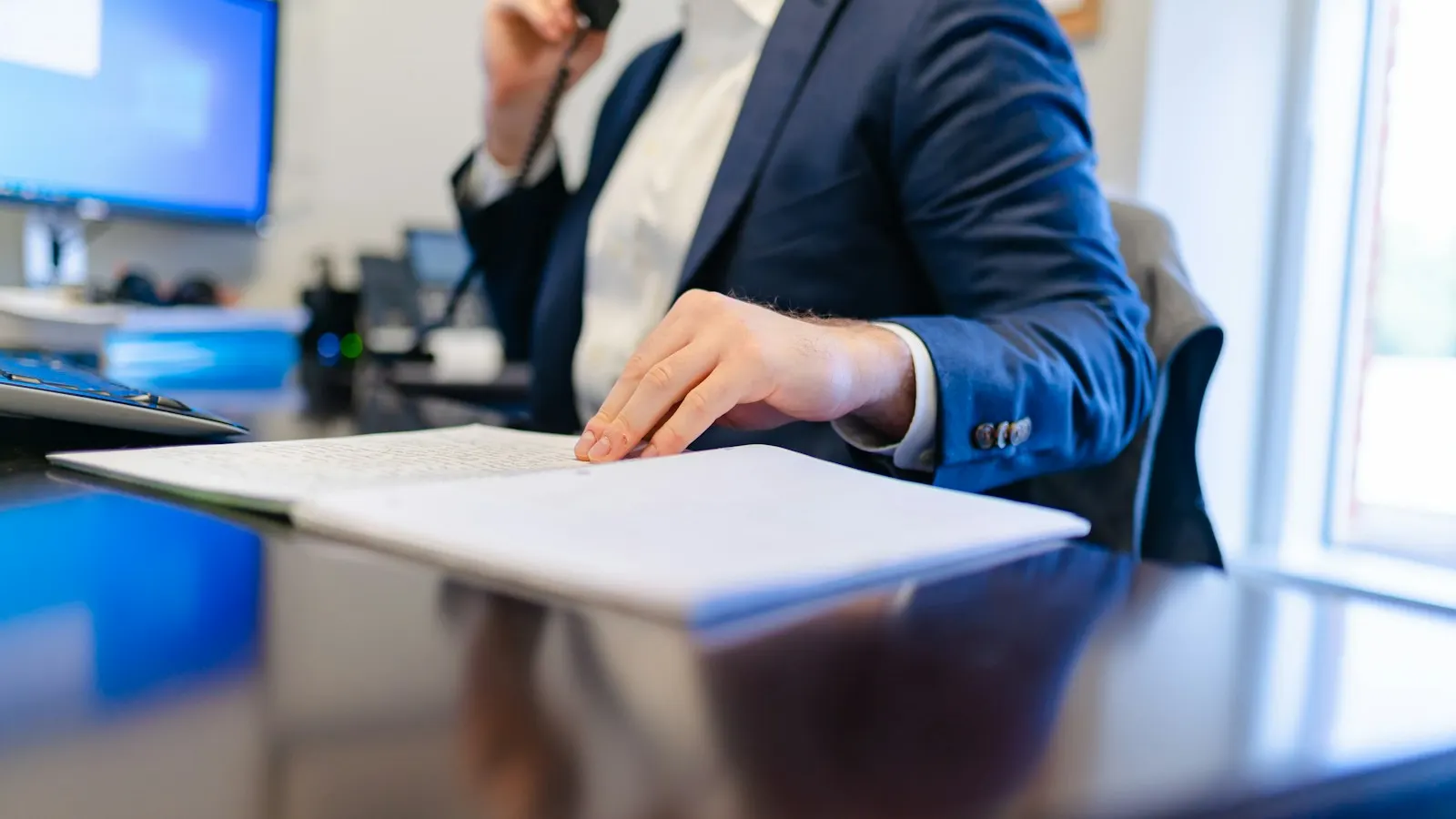 An agent on the phone at his desk with a document