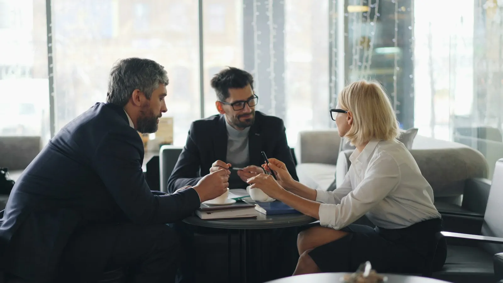 Three colleagues meeting around a table in an office