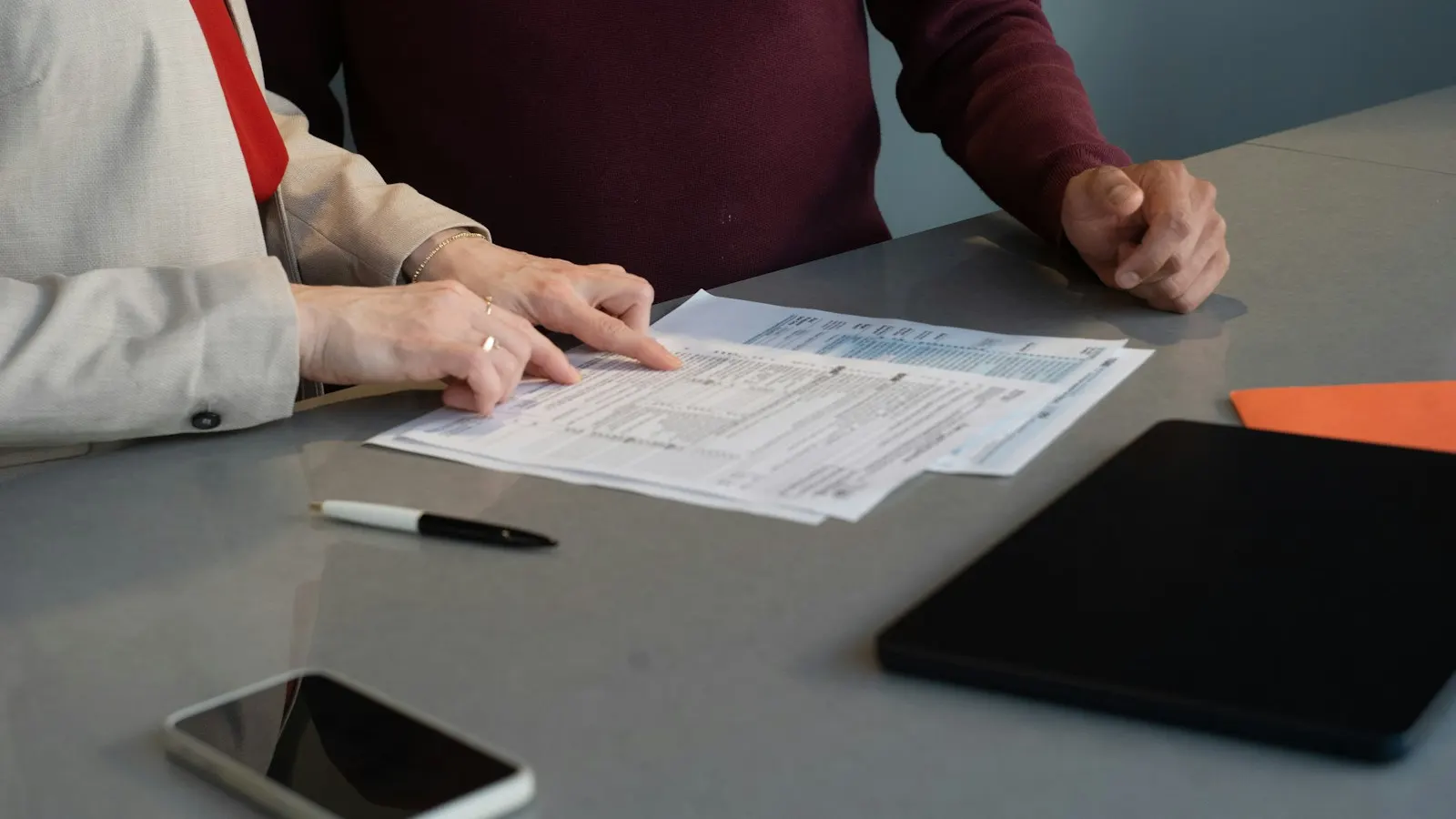 Two people reviewing insurance paperwork at a table