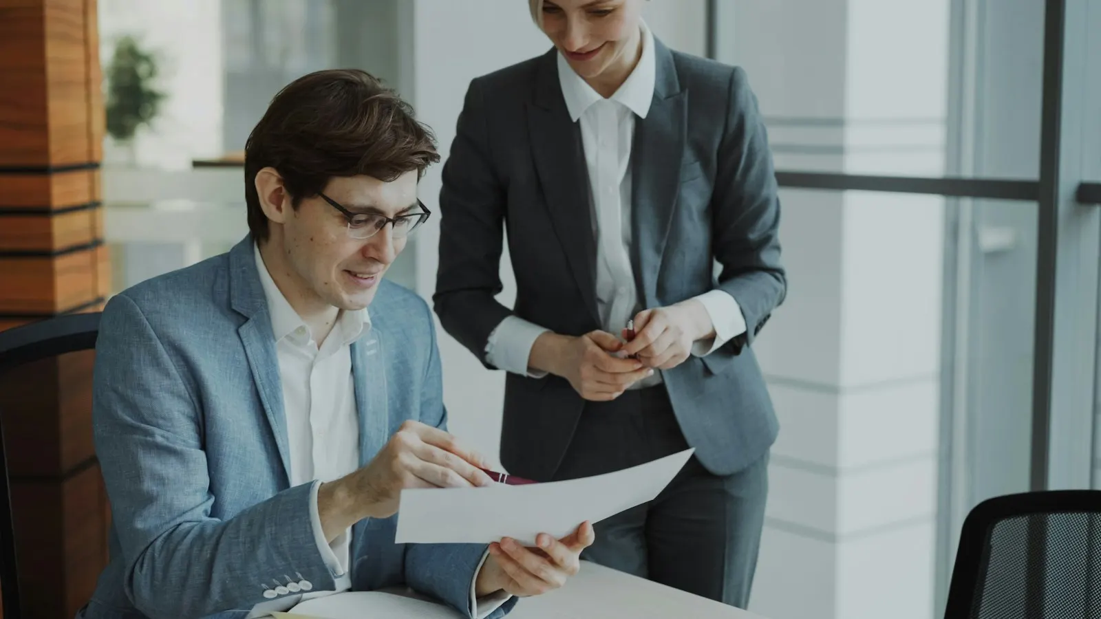 Two colleagues reviewing a document together in an office