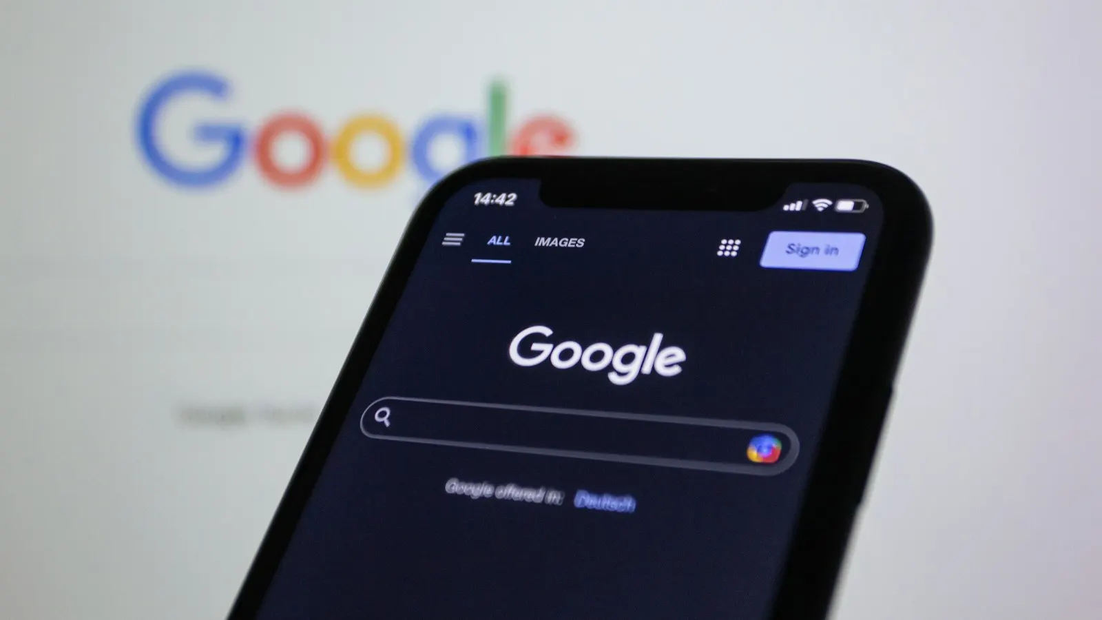 A smartphone showing Google search in front of the Google logo