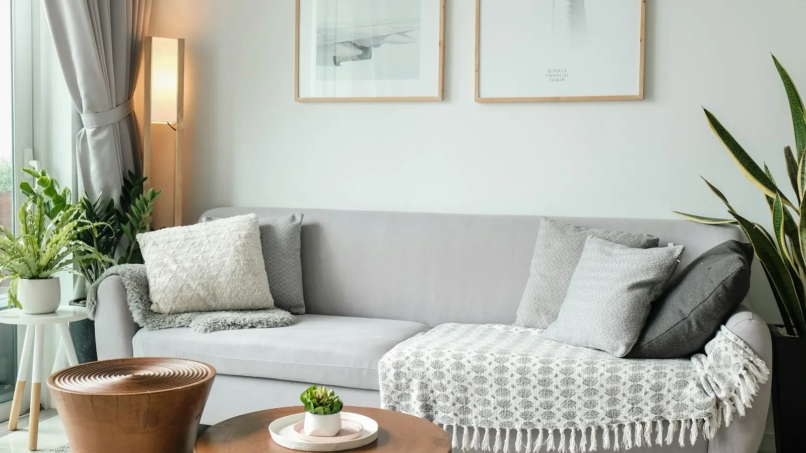 A neatly staged living room with a sofa and coffee tables