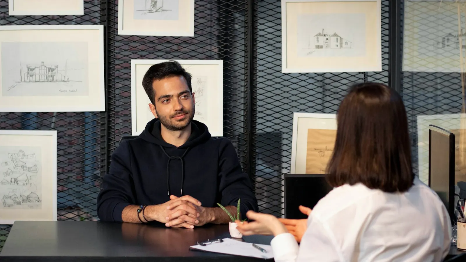 A hiring manager interviewing a candidate across a desk