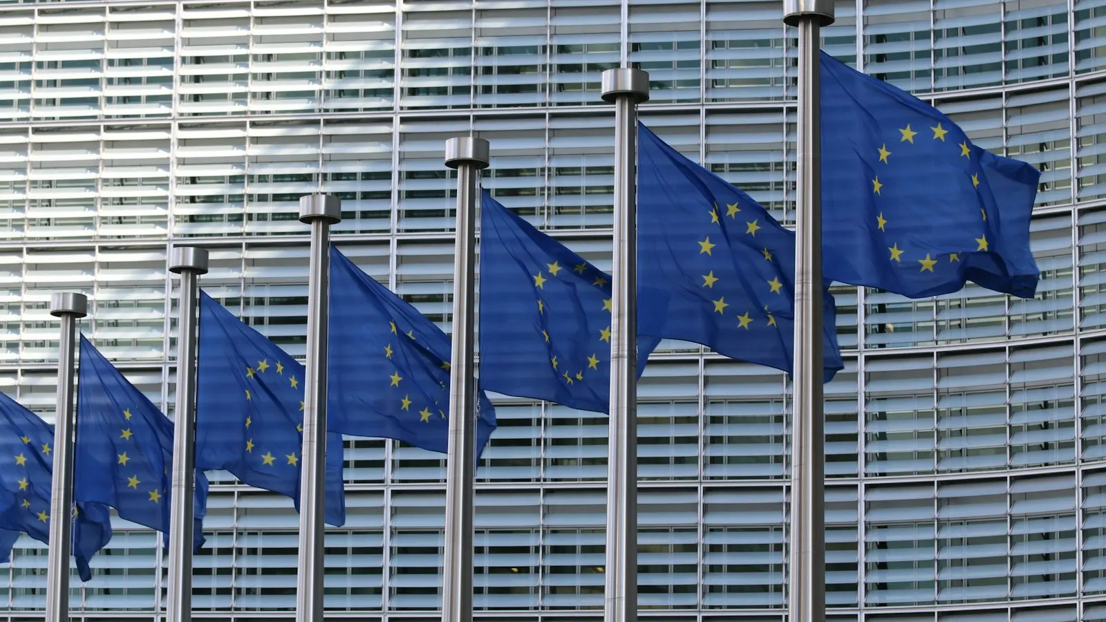 A row of European Union flags outside the European Commission