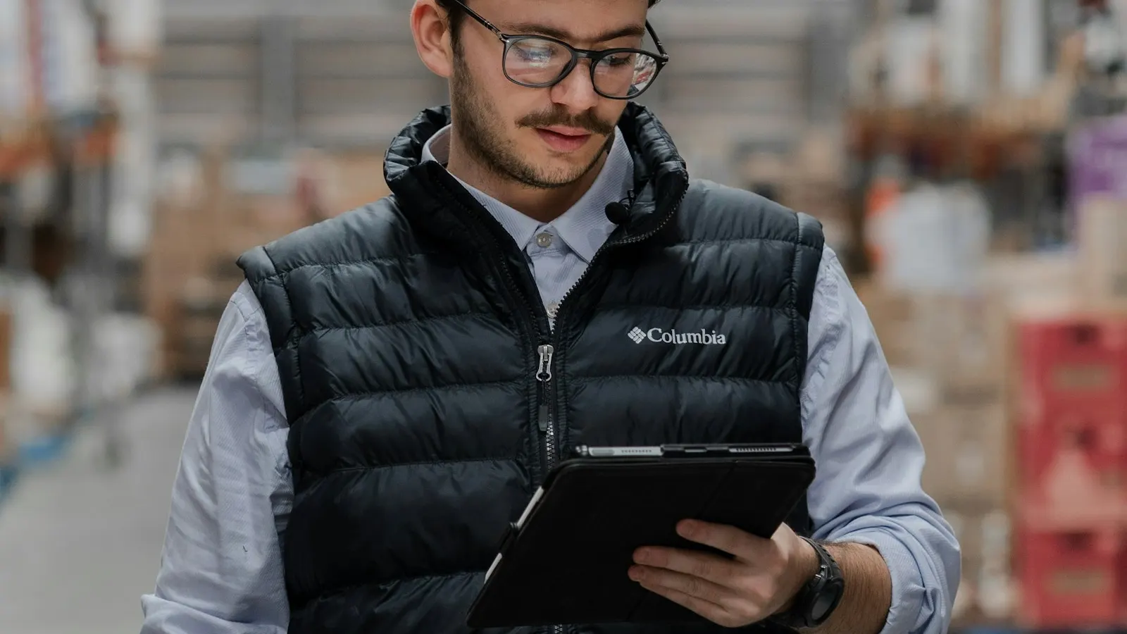 A manager using a tablet in a warehouse