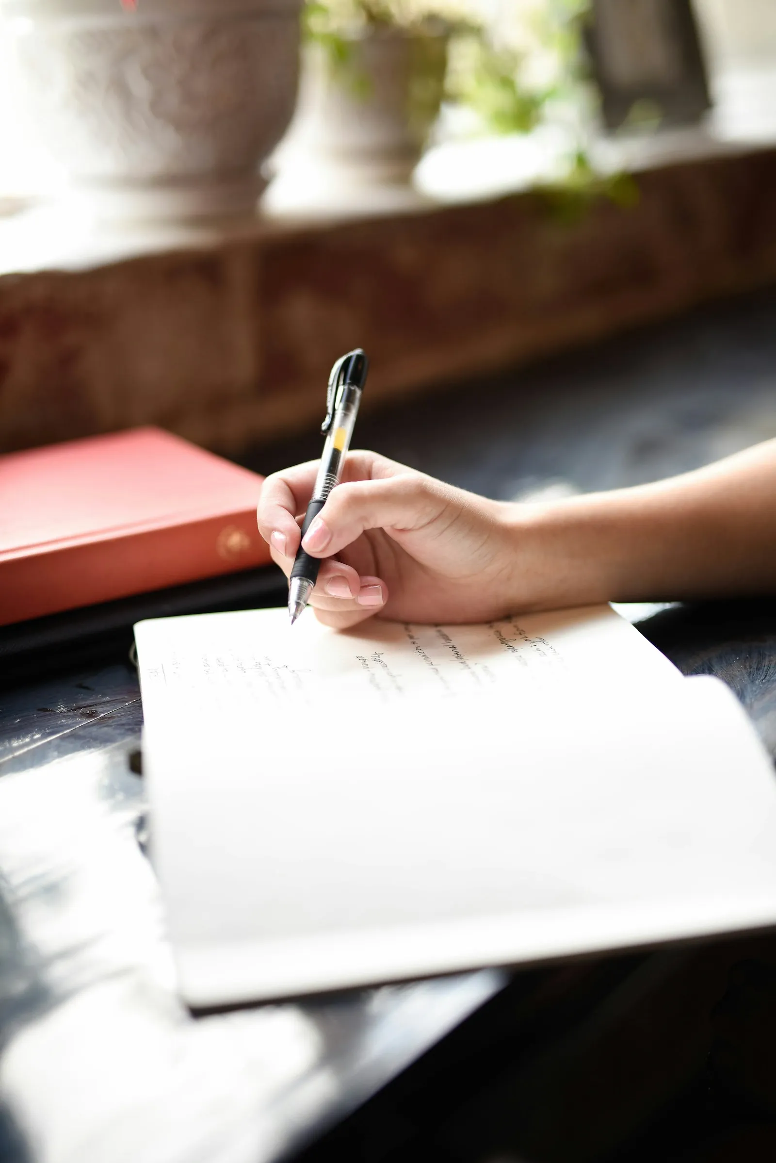 A clinician writing notes in a notebook